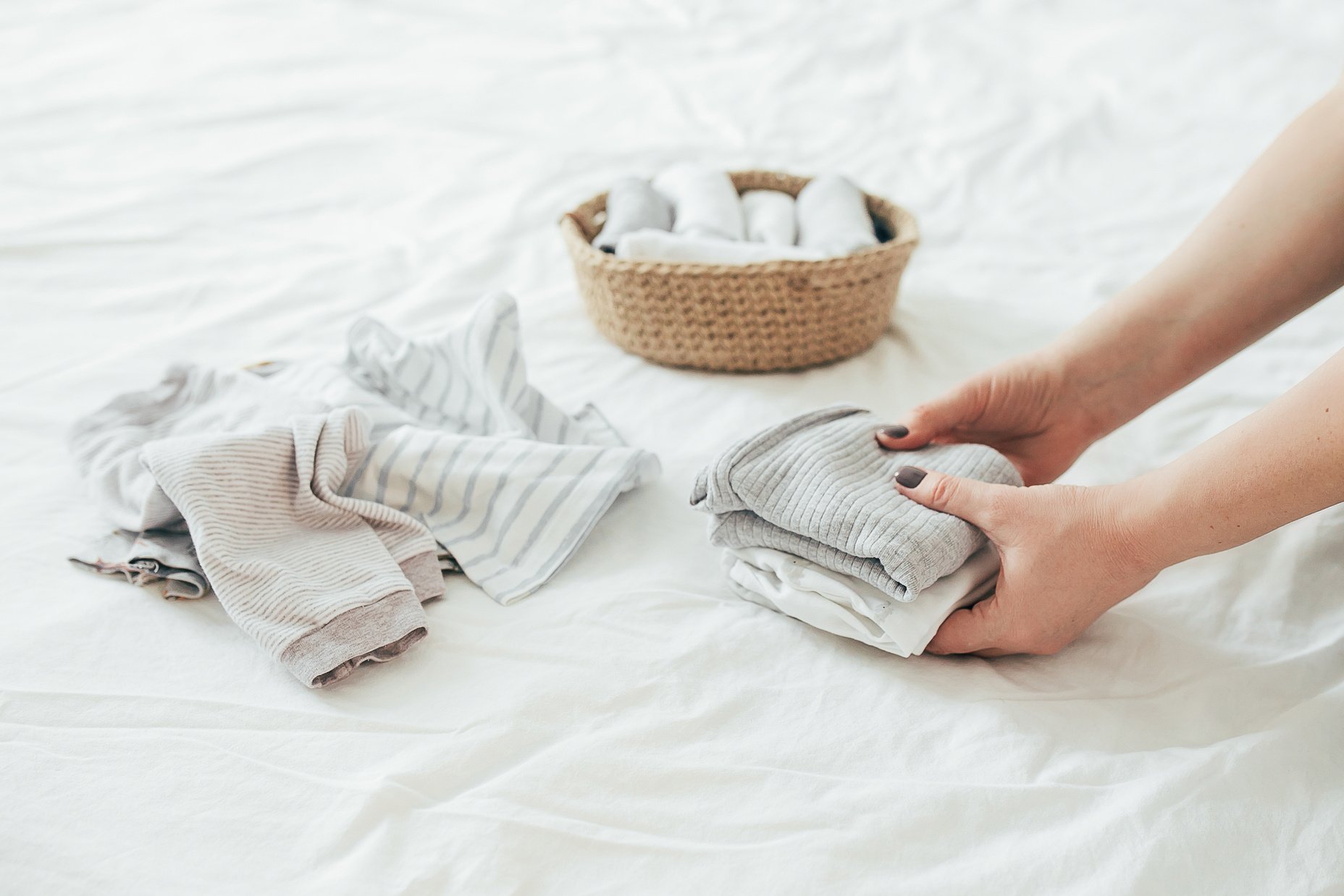 Close Up of Person Folding Clothes in the Bed